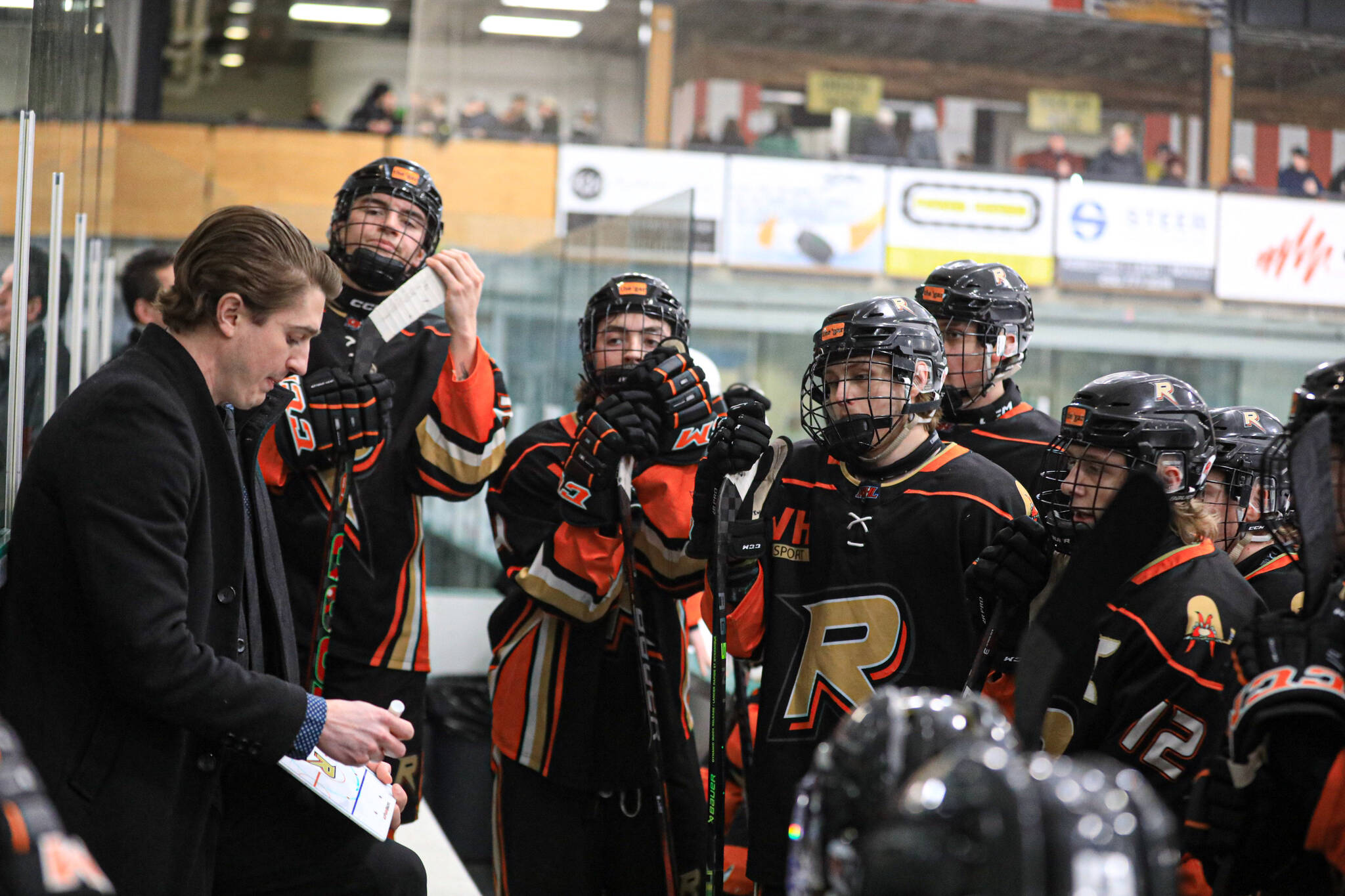 Castlegar Rebels gather around coach Nick Headrick during a Feb. 16 game against the Nelson Leafs.