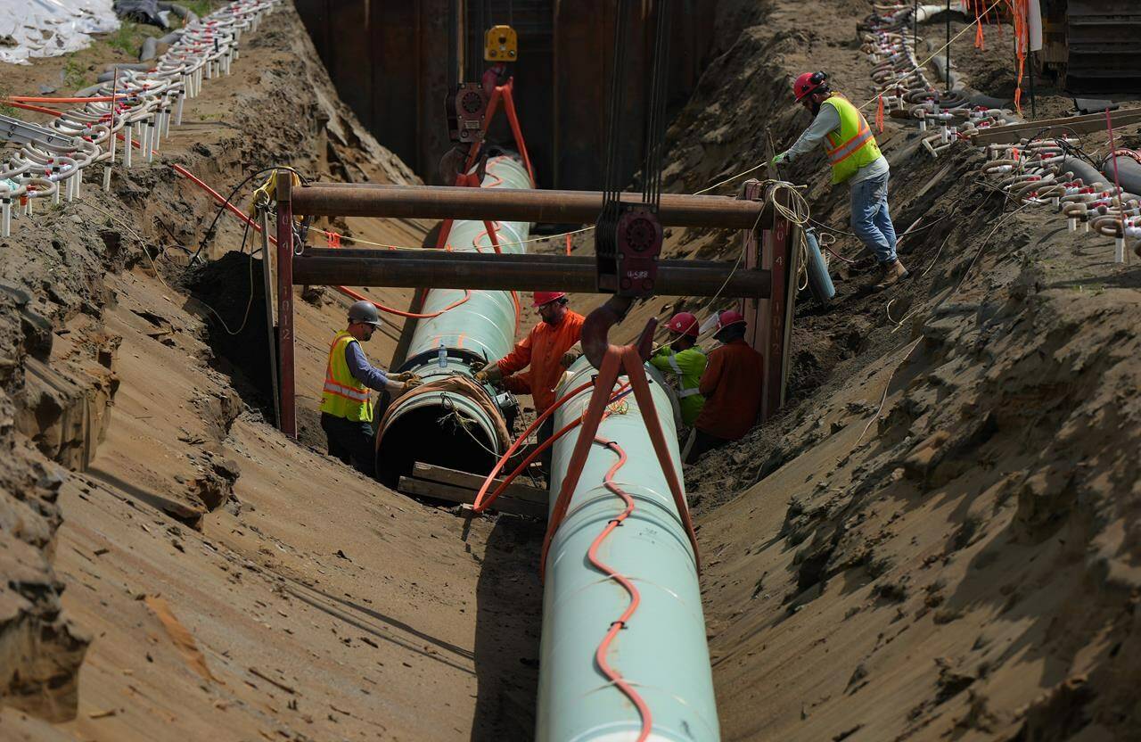 Workers lay pipe during construction of the Trans Mountain pipeline in Abbotsford, B.C., on Wednesday, May 3, 2023. THE CANADIAN PRESS/Darryl Dyck