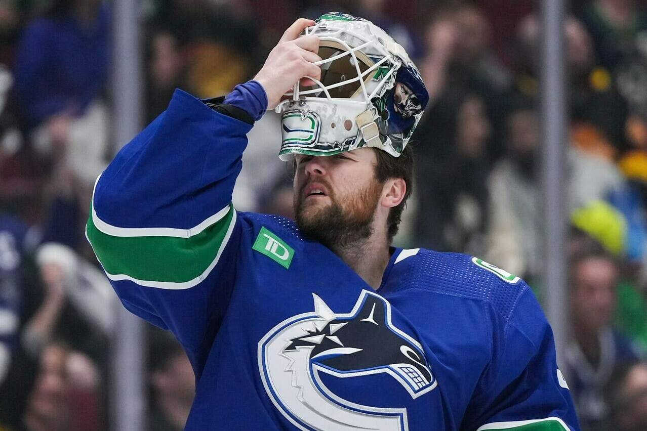 Vancouver Canucks goalie Thatcher Demko puts his mask back on after it was struck by a puck during the second period in Game 1 of an NHL hockey Stanley Cup first-round playoff series against the Nashville Predators in Vancouver on Sunday, April 21, 2024. THE CANADIAN PRESS/Darryl Dyck