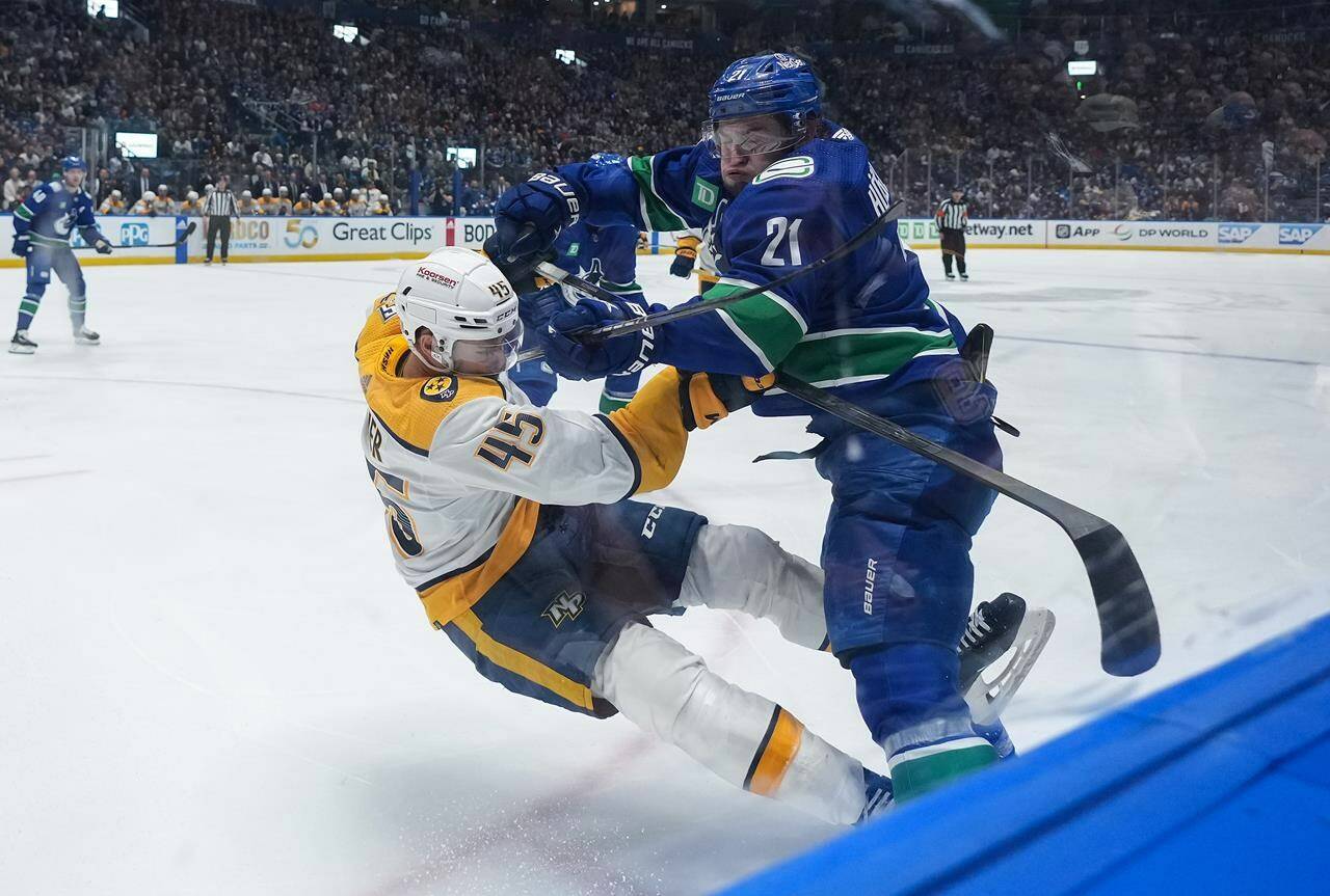 Vancouver Canucks’ Nils Hoglander (21) checks Nashville Predators’ Alexandre Carrier (45) during the first period in Game 5 of an NHL hockey Stanley Cup first-round playoff series, in Vancouver, on Tuesday, April 30, 2024. THE CANADIAN PRESS/Darryl Dyck