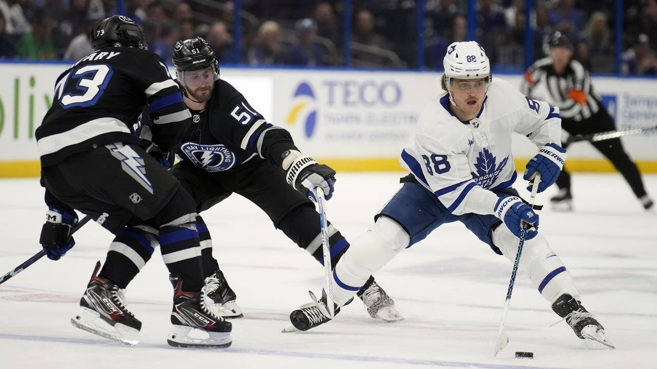Toronto Maple Leafs right wing William Nylander (88) works around Tampa Bay Lightning left wing Austin Watson (51) and left wing Conor Sheary (73) during the first period of an NHL hockey game Wednesday, April 17, 2024, in Tampa, Fla. The hockey team once played home games at Maple Leaf Gardens. (AP Photo/Chris O’Meara)