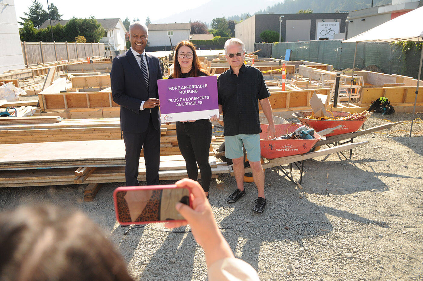 Kathleen Mosa, (centre) former executive director of Wilma’s Transition Society, is being sued by the society for misappropriation. Mosa is flanked by Housing Minister Ahmed Hussen and Chilliwack Mayor Ken Popove at an affordable housing announcement in Chilliwack on Thursday, July 28, 2022. (Jenna Hauck/ Chilliwack Progress file)