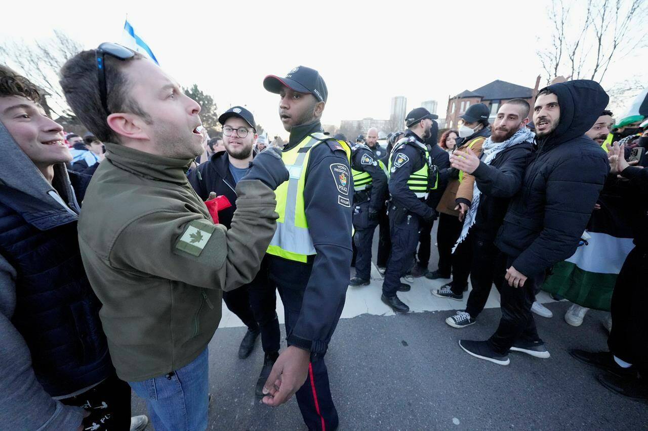 Pro-Israel protesters, left, and pro-Palestine protesters face off as police keep the two groups separate at a demonstration in front of a synagogue in Thornhill, Ont., Thursday, March 7, 2024. Newly released documents show federal officials had separate discussions with Jewish and Muslim leaders about the domestic turmoil being caused by the ongoing Israel-Hamas conflict. THE CANADIAN PRESS/Frank Gunn