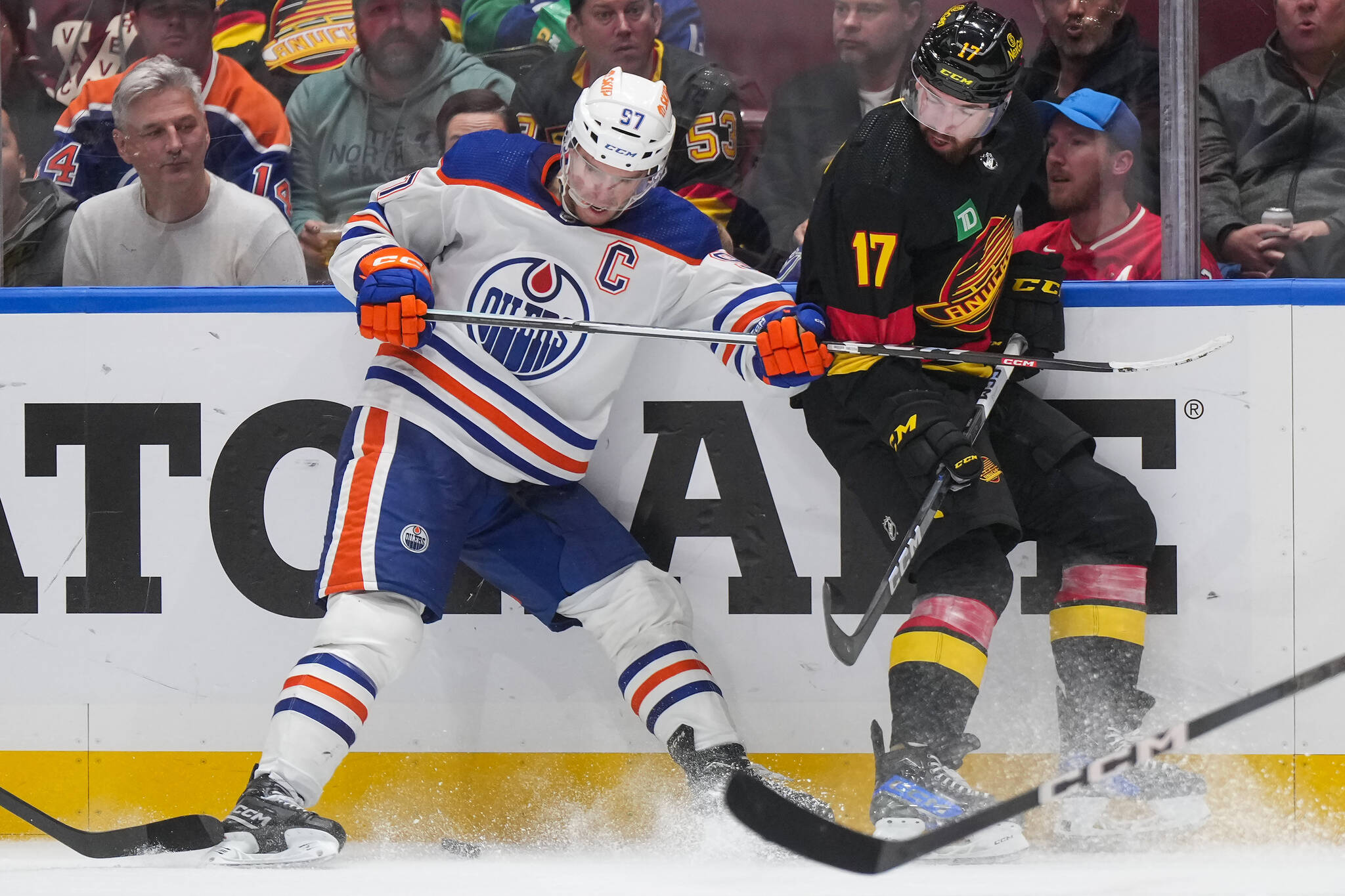 Edmonton Oilers’ Connor McDavid, left, and Vancouver Canucks’ Filip Hronek vie for the puck during the third period of an NHL hockey game in Vancouver, on Monday, November 6, 2023. THE CANADIAN PRESS/Darryl Dyck