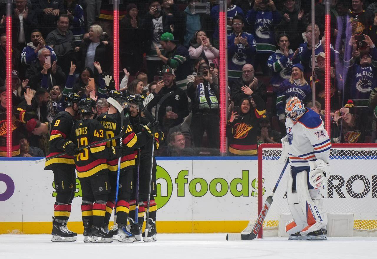 Vancouver Canucks’ J.T. Miller, from left to right, Quinn Hughes, Elias Pettersson, Andrei Kuzmenko and Brock Boeser, back left, celebrate Boeser’s goal against Edmonton Oilers goalie Stuart Skinner (74) during the first period of an NHL hockey game in Vancouver, on Monday, November 6, 2023. THE CANADIAN PRESS/Darryl Dyck