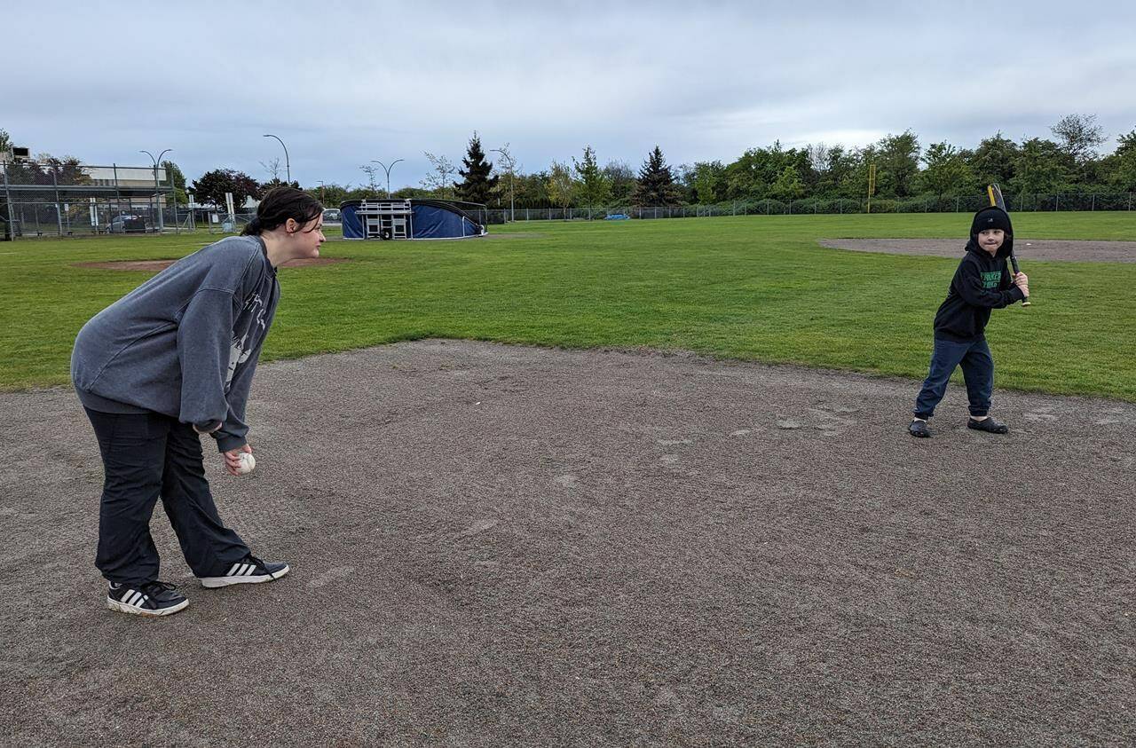 Siblings Ella Pringle and Aidan Ridley play baseball at a park in a handout photo as part of their parents’ “conscious” effort to get them out of the house and away from their screens for regular exercise as recommended in a ParticipAction report. THE CANADIAN PRESS/HO