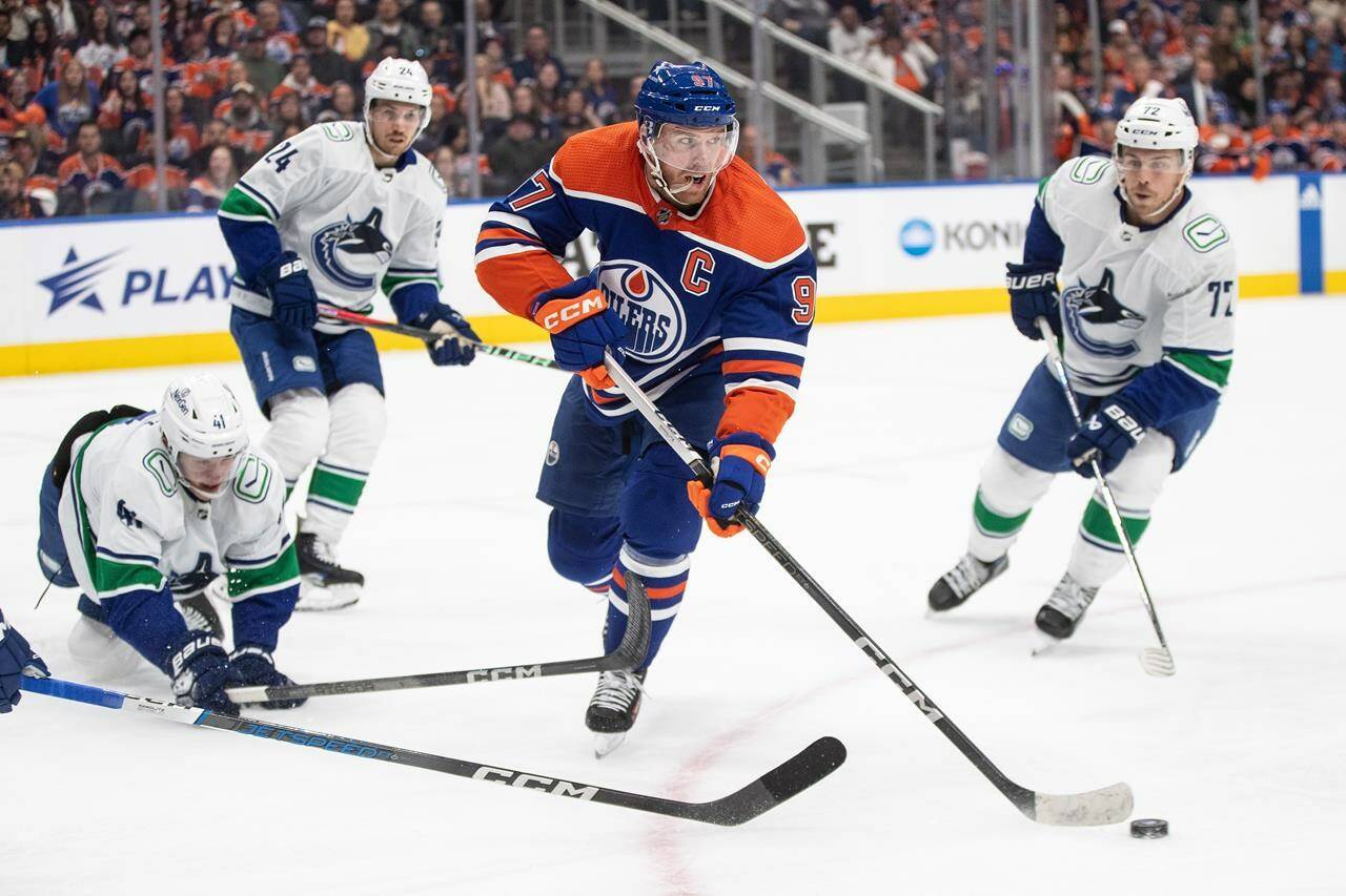 Vancouver Canucks chase Edmonton Oilers’ Connor McDavid (97) during second period NHL action in Edmonton, Saturday, Oct. 14, 2023. The Vancouver Canucks are set to host the Edmonton Oilers for Game 1 of their second-round series on Wednesday. THE CANADIAN PRESS/Jason Franson
