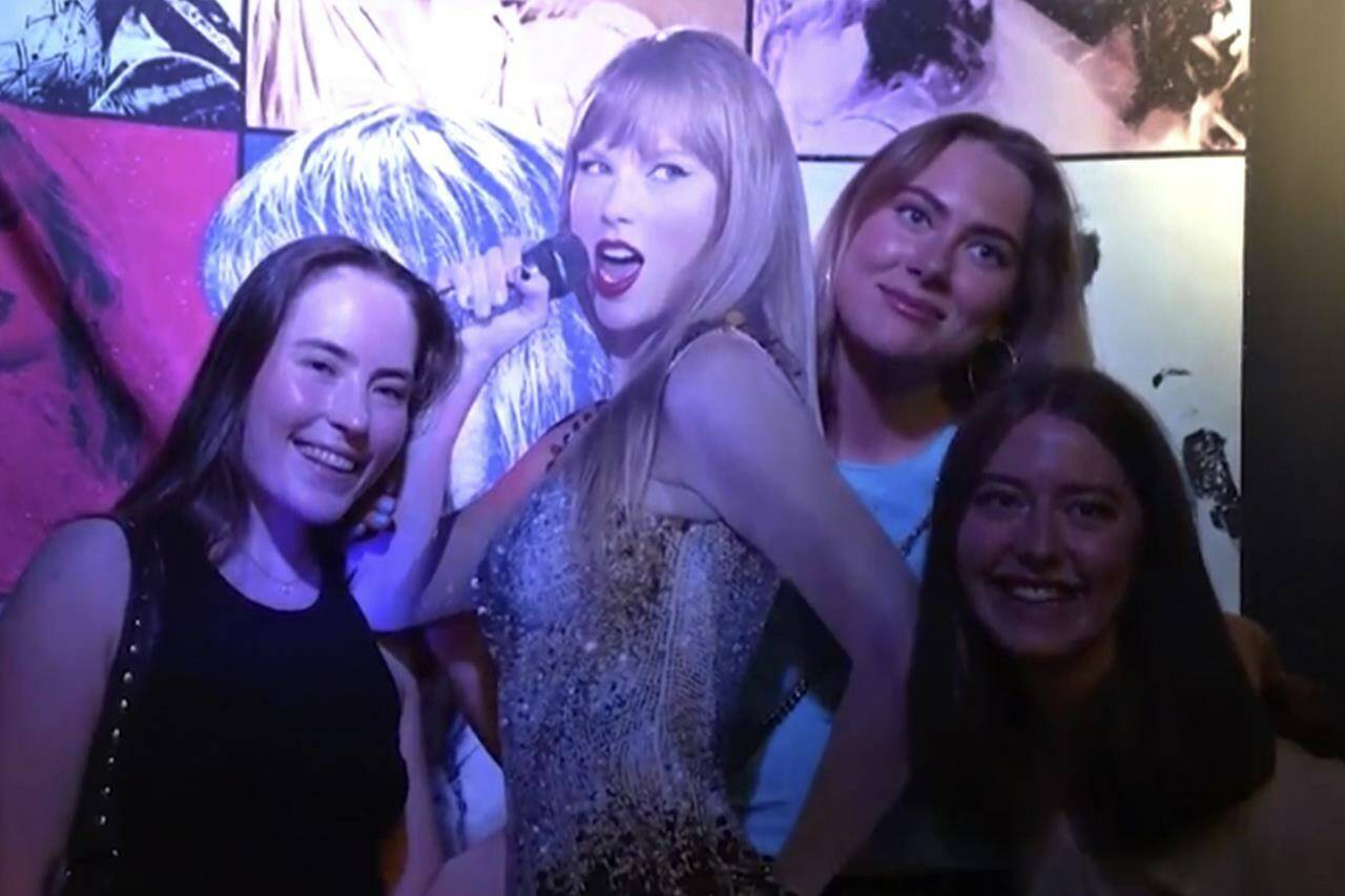 In this image taken from video, fans pose with a life-size image of Taylor Swift at a club that plays only Swift’s music in Gothenburg, Sweden, on Tuesday, April 30th, 2024. Swift is scheduled to kick off the 18-city Europe leg of her record-setting Eras Tour on Thursday, May 9, 2024. There will be three shows in Stockholm. (AP Photo/Chisato Tanaka)