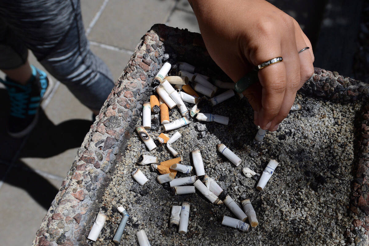 A smoker puts out a cigarette in a public ash tray in Ottawa on Tuesday, May 31, 2016. An April 2024 Research Co poll found 65 per cent of Canadians have a positive view of a new UK law that increases the age limit for buying cigarattes by a year every year. THE CANADIAN PRESS/Sean Kilpatrick
