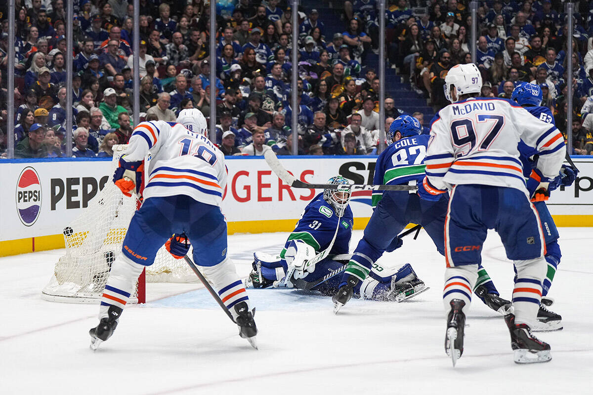 Vancouver Canucks goalie Arturs Silovs (31) allows the winning goal to Edmonton Oilers’ Evan Bouchard, not seen, as Zach Hyman (18), Connor McDavid (97) and Vancouver’s Ian Cole (82) watch during the first overtime period in Game 2 of an NHL hockey Stanley Cup second-round playoff series, in Vancouver, on Friday, May 10, 2024. THE CANADIAN PRESS/Darryl Dyck