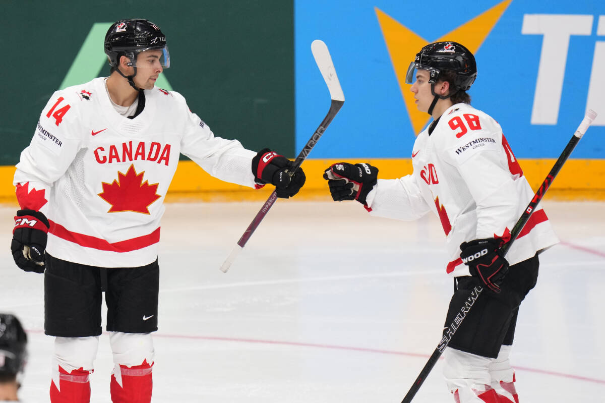 Canada’s Connor Bedard, right, celebrates with Canada’s Dylan Guenther after scoring his sides second goal during the preliminary round match between Denmark and Canada at the Ice Hockey World Championships in Prague, Czech Republic, Sunday, May 12, 2024. (AP Photo/Petr David Josek)