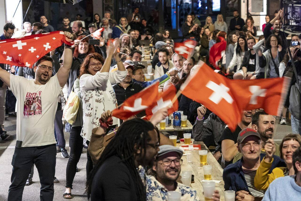 Supporters of singer Nemo, finalist of the 68th Eurovision Song Contest ESC, celebrate during a public viewing watching the broadcast of the ESC finals as Nemo is declared winner of the competition, in the early hours of Sunday, May 12, 2024, in Biel, Switzerland. Biel is Nemo’s hometown. (Adrian Reusser/Keystone via AP)