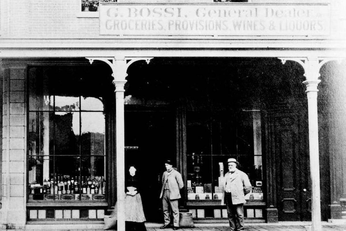 Giacomo Bossi store at the corner of Johnson and Store Streets, Victoria; left to right, Angelica Bossi, Americo Bossi and Giacomo Bossi. Circa 1870s. (BC Archives)