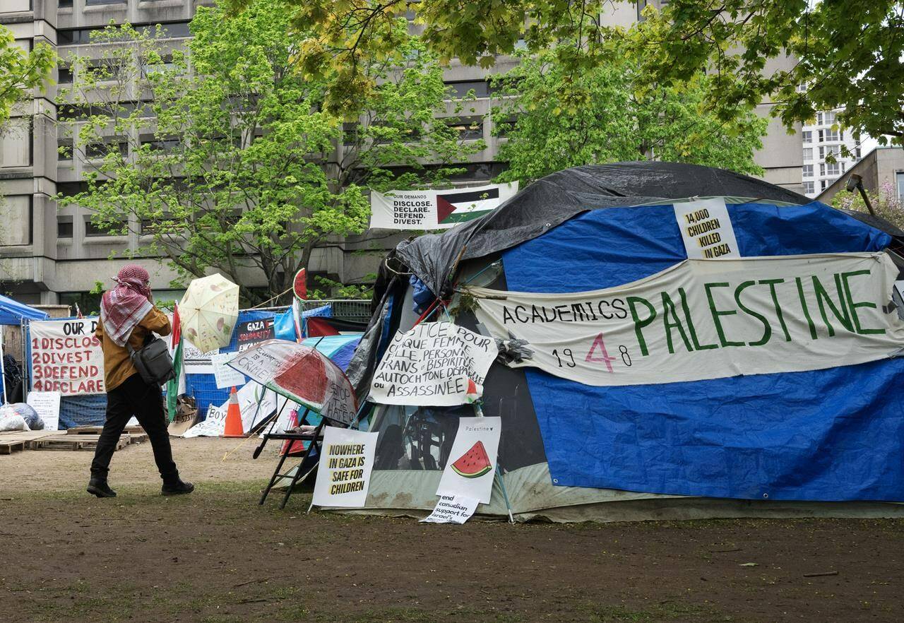 A person walks past the pro-Palestinian encampment on McGill University campus, in Montreal on May 13, 2024. THE CANADIAN PRESS/Ryan Remiorz