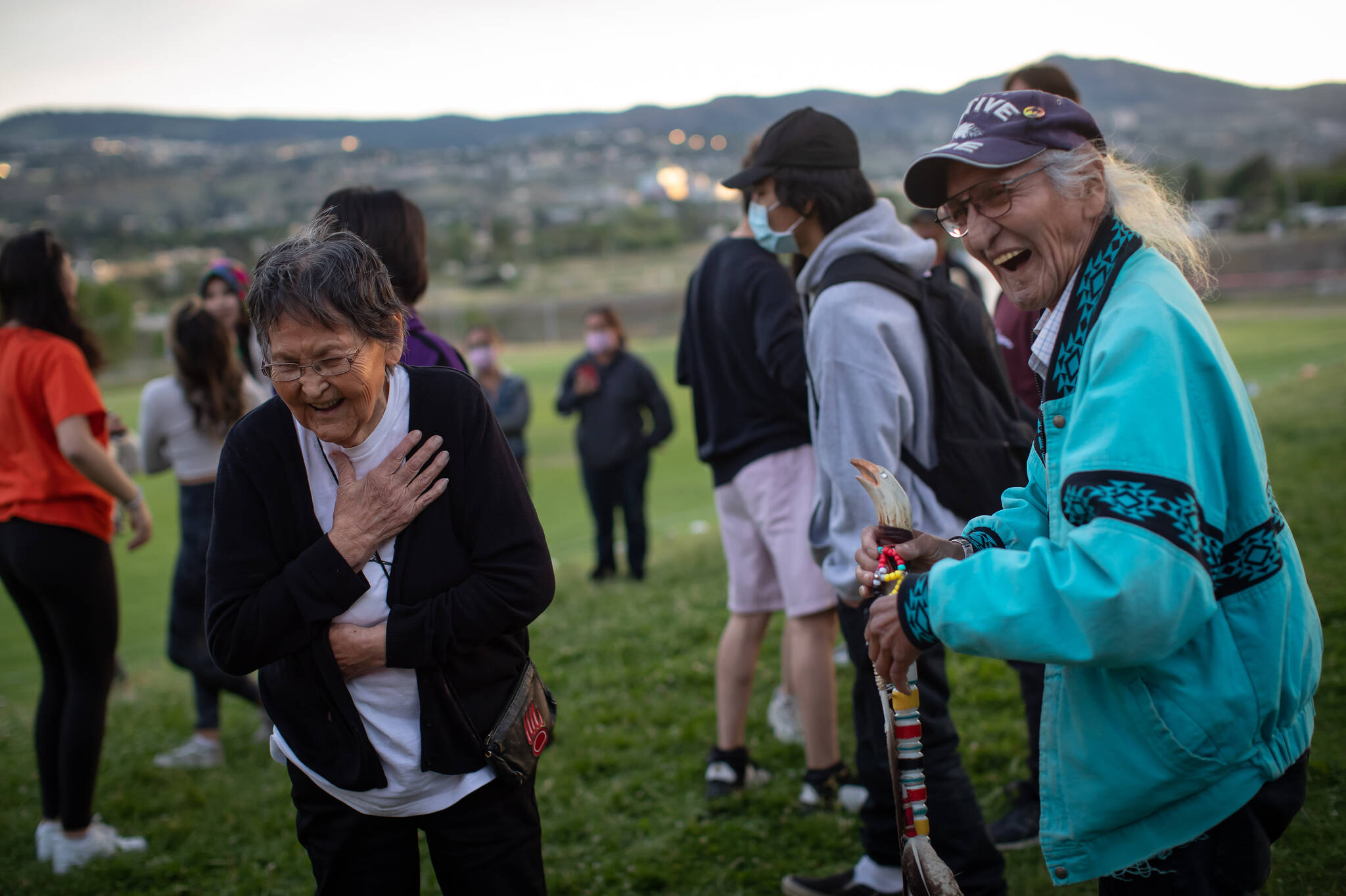 Lejac Residential School survivor Mary Nooski, left, 80, of the Stellat’en First Nation, and Kamloops Indian Residential School survivor Stanley Paul, 75, who was forced into the school when he was 7 and escaped by running away to the United States when he was 16, share a laugh outside the former school, in Kamloops, B.C., on Friday, June 4, 2021. The remains of 215 children have been discovered buried near the former school. THE CANADIAN PRESS/Darryl Dyck