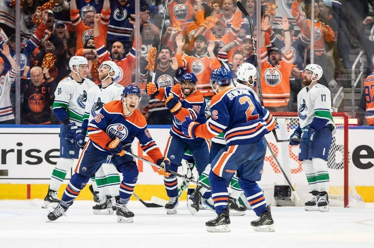 Edmonton Oilers' Evan Bouchard (2), Dylan Holloway (55) and Evander Kane (91) celebrate a goal against the Vancouver Canucks during third period second-round NHL playoff action in Edmonton on Tuesday May 14, 2024.THE CANADIAN PRESS/Jason Franson