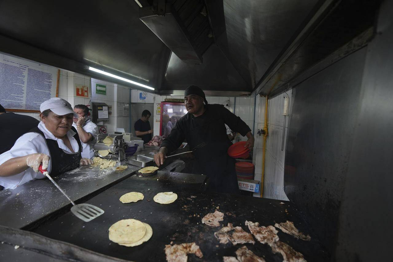 A worker warms corn tortillas on a griddle at the Tacos El Califa de León taco stand, in Mexico City, Wednesday, May 15, 2024. Tacos El Califa de León is the first ever taco stand to receive a Michelin star from the French dining guide. (AP Photo/Fernando Llano)