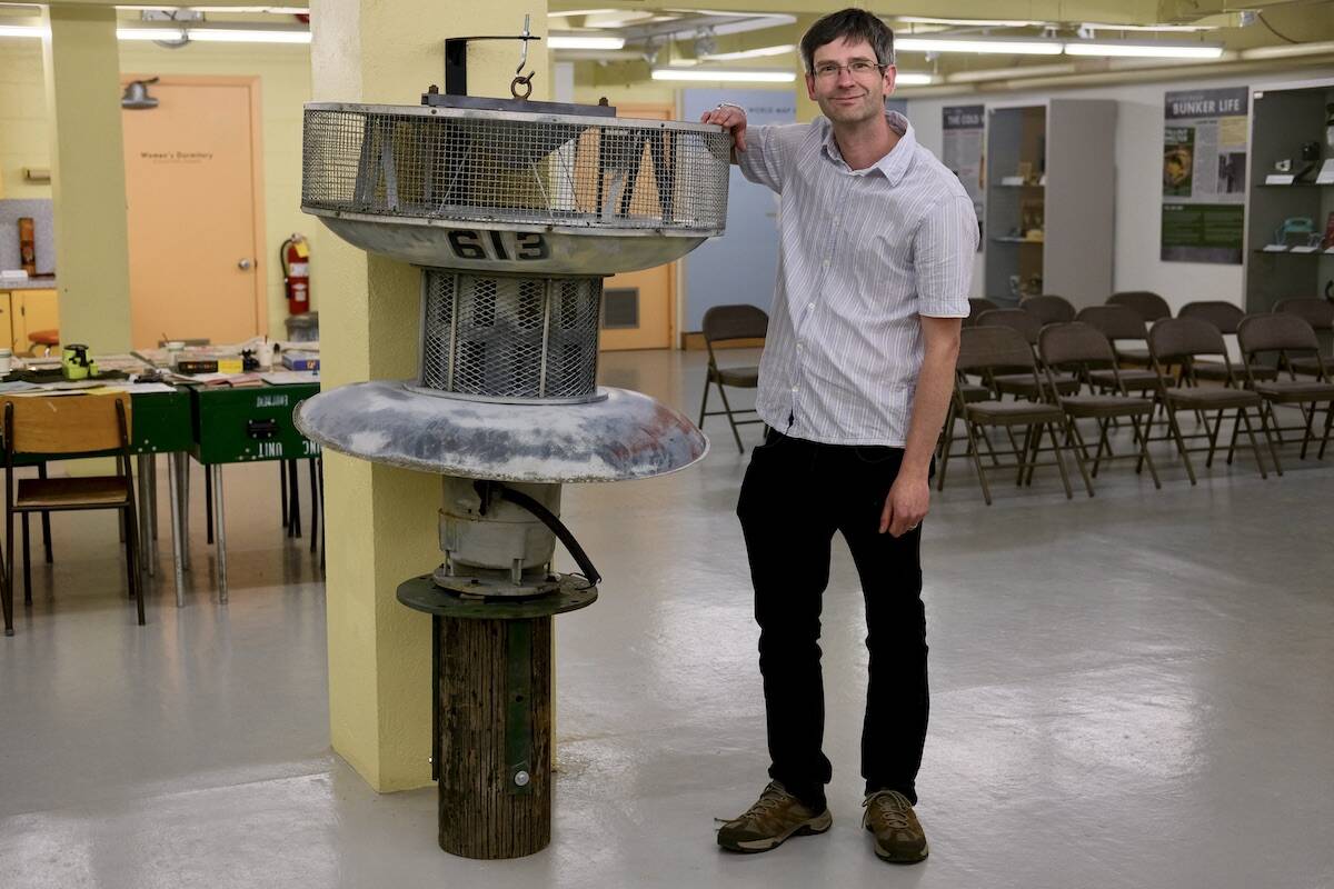 Jean-Philippe Stienne, archivist at the Nelson Museum Archives and Gallery, stands in the Cold War Bunker with one of the air raid sirens installed in Nelson in 1963. Photo: Bill Metcalfe