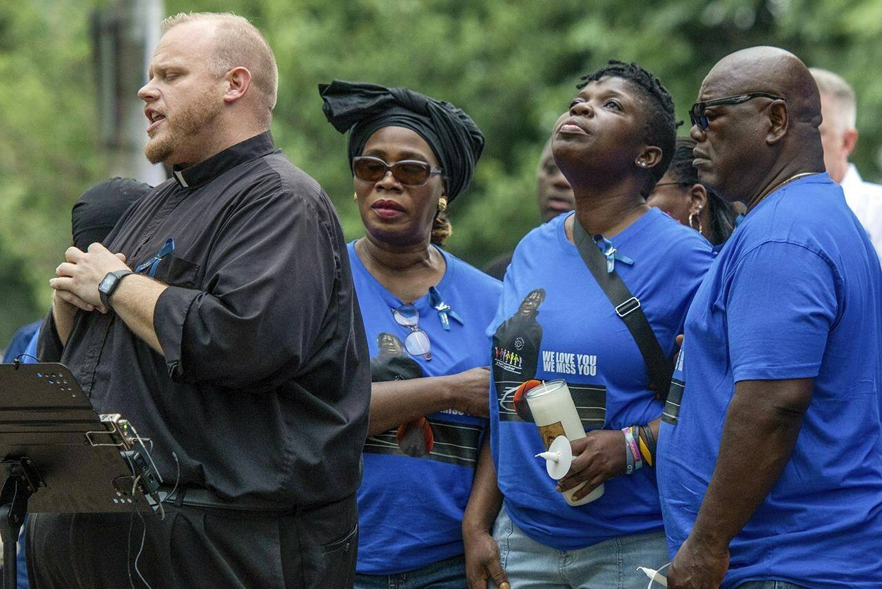 FILE Rev. Jonathan Slavinskas, left, prays with the family of Harris Wolobah, including mother Lois and father Amos Wolobah, right, during a vigil in Newton Square Friday, Sept. 8, 2023 in Worcester, Mass. A medical examiner says a Massachusetts teen who participated in a spicy tortilla chip challenge died from ingesting a substance “with a high capsaicin concentration,” according to autopsy results The Associated Press obtained late Wednesday, May 15, 2024. Capsaicin is a chili pepper extract. Harris Wolobah died on Sept. 1, 2023, after eating the chip. (Rick Cinclair/Worcester Telegram & Gazette via AP, File)