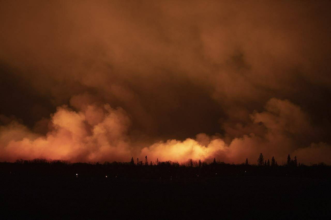 A forest fire burns late into the evening northeast of Prince Albert, Sask., on Monday, May 17, 2021. THE CANADIAN PRESS/Kayle Neis