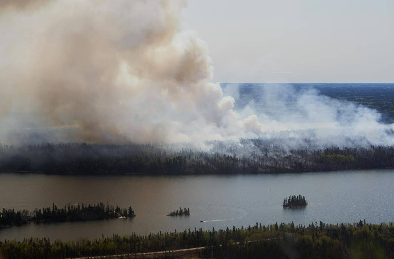 As more Canadians grapple with catastrophic impacts from climate-fuelled extreme weather, from wildfires to deadly heat waves, the question of how a person can keep up the fight for planetary health while tending to their mental health has extended beyond the environmental movement and become more urgent and widespread. A wildfire burns in northern Manitoba near Flin Flon, as seen from a helicopter surveying the situation, Tuesday, May 14, 2024. THE CANADIAN PRESS/David Lipnowski