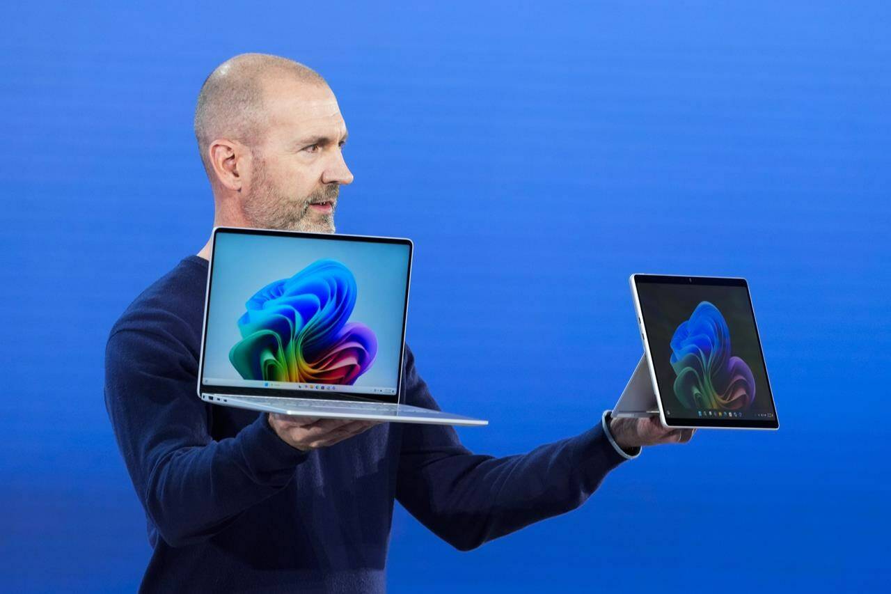 Brett Ostrum, Microsoft corporate vice president of Surface, holds up the new Surface Laptop and Surface Pro with built-in AI hardware during a showcase event of the company’s AI assistant, Copilot, at Microsoft headquarters, Monday, May 20, 2024, in Redmond, Wash. (AP Photo/Lindsey Wasson)