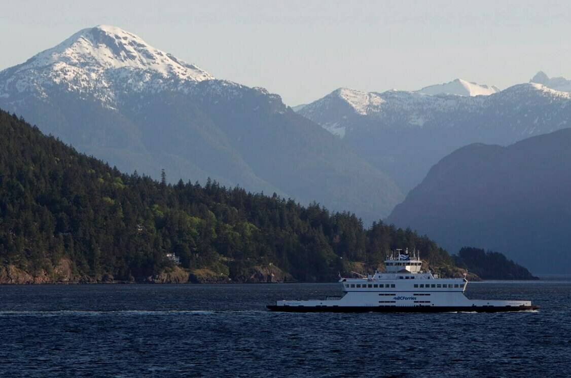 The snow capped mountains are seen in the background as a ferry crosses Howe Sound outside of West Vancouver, B.C. Monday, May 14, 2012. THE CANADIAN PRESS/Jonathan Hayward