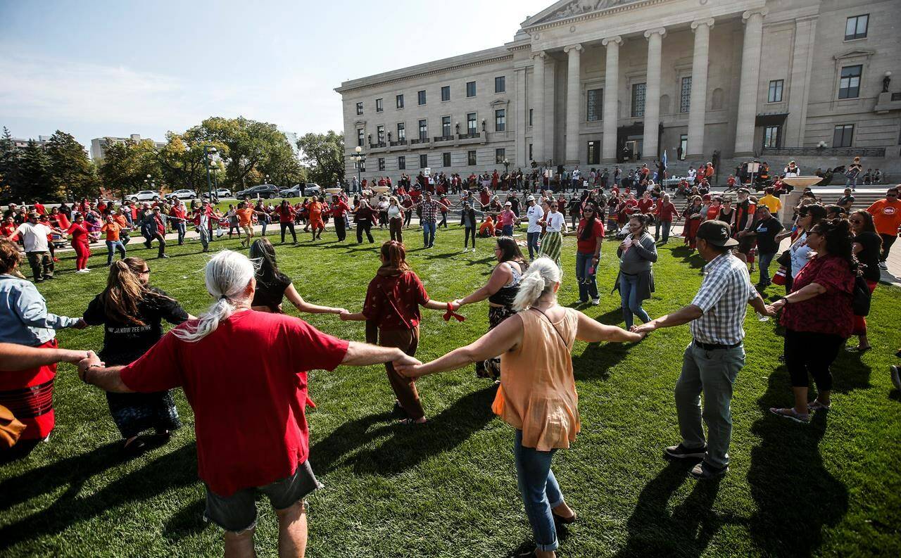 Supporters and family members round dance as they gather at a rally to search a landfill for three missing women at the Manitoba legislature in Winnipeg on Monday, Sept. 18, 2023. THE CANADIAN PRESS/John Woods