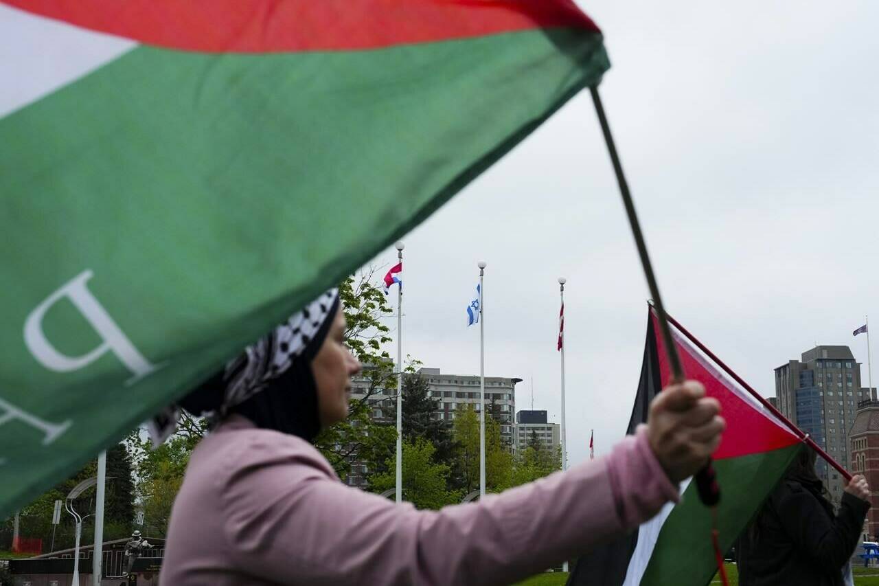 The Ottawa police hate crime unit have charged an unnamed elderly woman with assault, after they say she removed another woman’s headscarf near a protest about events in the Middle East. Pro-Palestinian protesters rally at Ottawa City Hall after the city raised the Israeli flag in Ottawa, Tuesday, May 14, 2024. THE CANADIAN PRESS/Sean Kilpatrick
