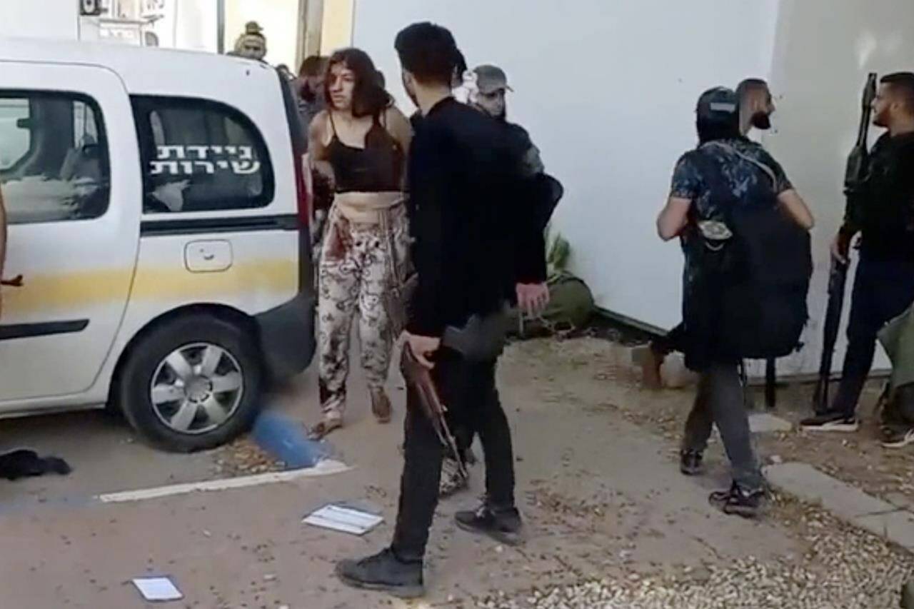 In this image taken from video provided by the Hostage Families Forum, an Israeli female soldier, from the Nahal Oz military base, is marched to a vehicle by Hamas after she was taken captive on Oct. 7, 2023. The footage was taken by Hamas militants who stormed the Nahal Oz military base, part of the militant group’s wider assault on southern Israel that killed roughly 1,200 people and took about 250 others hostage. (Hostage Families Forum via AP)