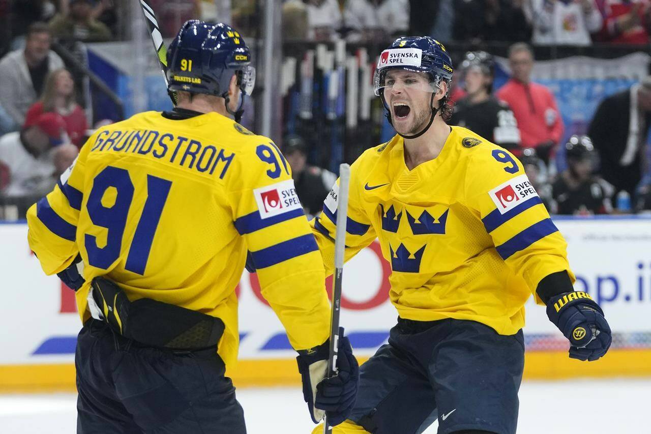 Sweden’s Carl Grundstrom, left, celebrates with Sweden’s Adrian Kempe after scoring his sides third goal during the bronze medal match between Sweden and Canada at the Ice Hockey World Championships in Prague, Czech Republic, Sunday, May 26, 2024. (AP Photo/Petr David Josek)