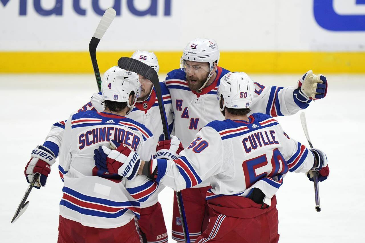 New York Rangers center Barclay Goodrow, right rear, celebrates with teammates after he scored in the first period of Game 3 during the Eastern Conference finals of the NHL hockey Stanley Cup playoffs against the Florida Panthers, Sunday, May 26, 2024, in Sunrise, Fla. (AP Photo/Wilfredo Lee)