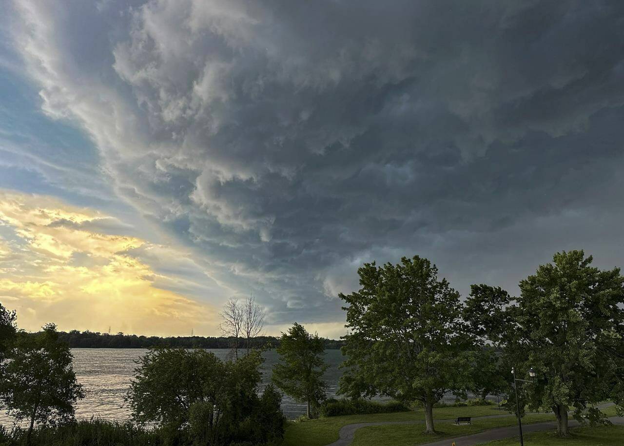 Storm clouds move across the sky as Environment Canada issued tornado warnings Thursday, July 13, 2023 in Montreal. A suspected tornado that touched down in southwestern Quebec has damaged homes and farm buildings, but a local fire official says there have been no injuries. THE CANADIAN PRESS/Christinne Muschi