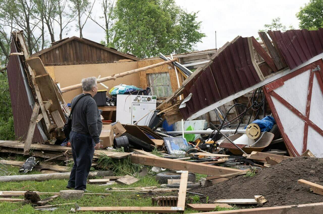 A man looks at the damage in Très-Saint-Rédempteur, Que., on Tuesday, May 28, 2024 after a tornado went through the prior evening.THE CANADIAN PRESS/Ryan Remiorz