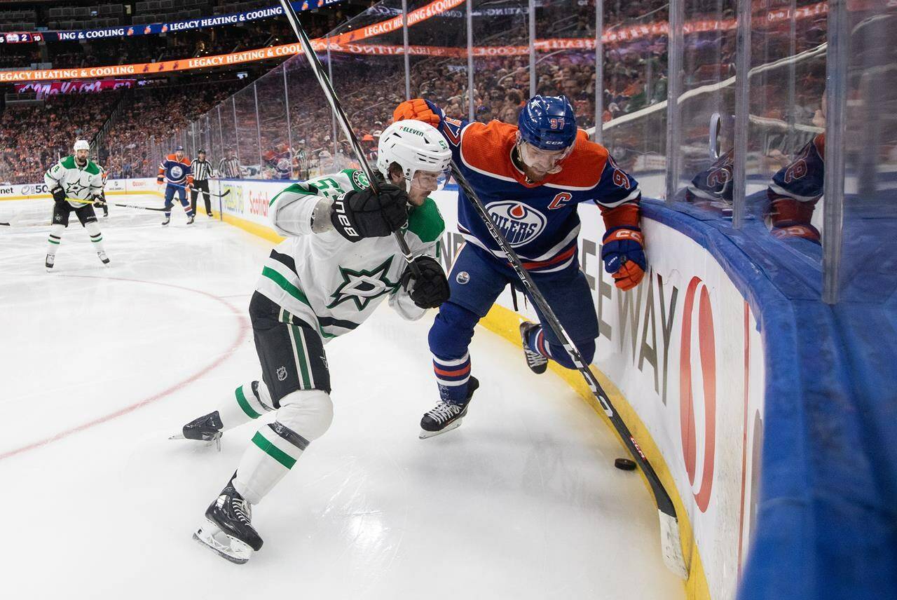 Dallas Stars’ Wyatt Johnston (53) and Edmonton Oilers’ Connor McDavid (97) battle for the puck during second period third-round NHL playoff action in Edmonton on Monday May 27, 2024.THE CANADIAN PRESS/Jason Franson