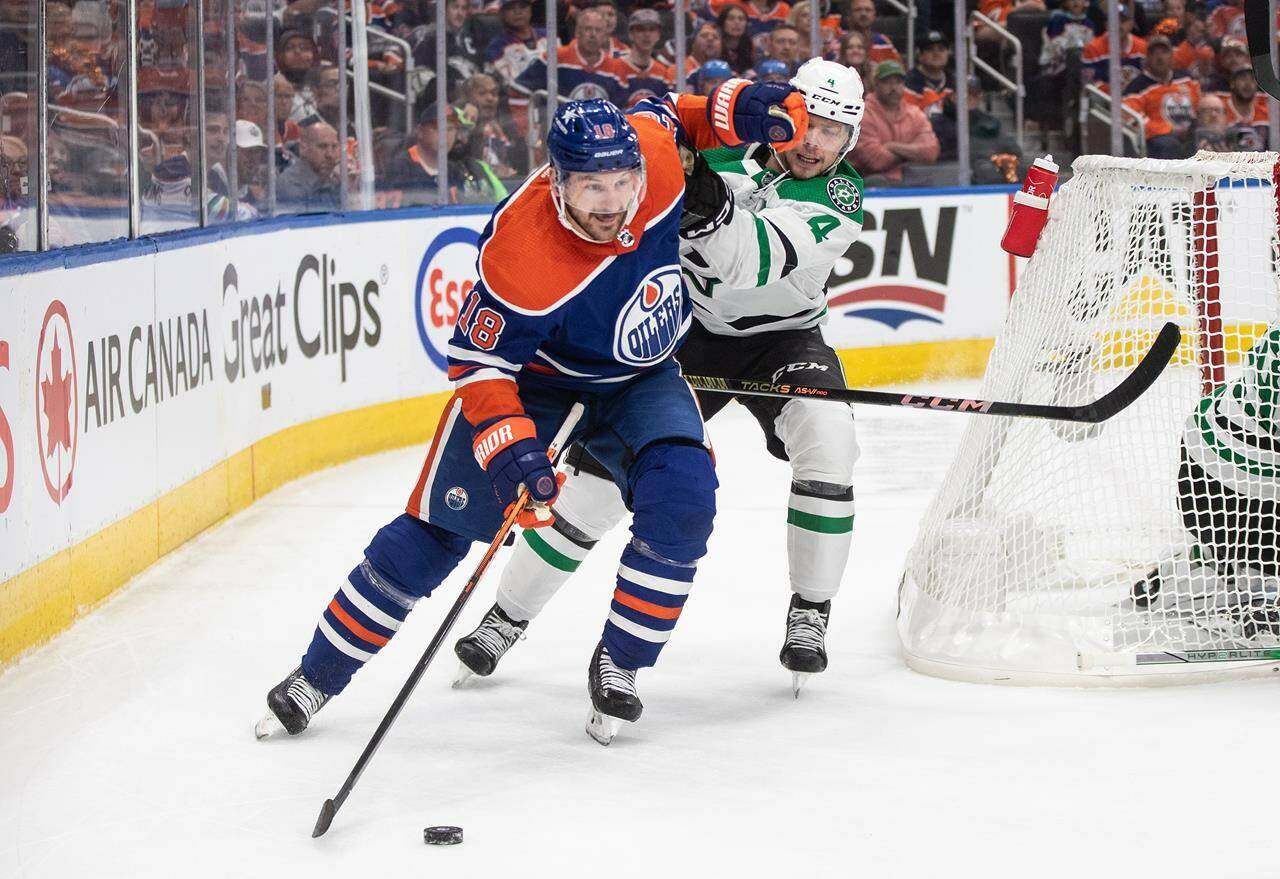 Dallas Stars' Miro Heiskanen (4) and Edmonton Oilers' Zach Hyman (18) battle for the puck during second period action in game 4 of the Western Conference finals of the NHL Stanley Cup playoffs in Edmonton on Wednesday May 29, 2024.THE CANADIAN PRESS/Jason Franson