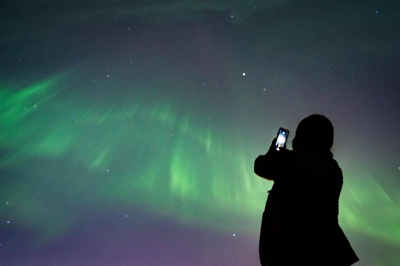 The northern lights could return to the sky over parts of Canada as a sunspot that contributed to a recent stunning aurora display rotates back Earth-side. A person takes a photo of the northern lights in Vancouver, on Saturday, May 11, 2024. THE CANADIAN PRESS/Ethan Cairns