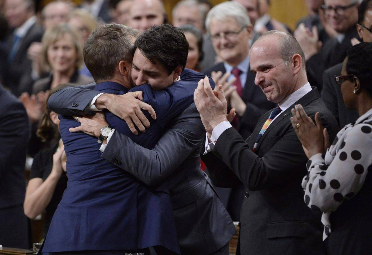 Prime Minister Justin Trudeau hugs Veteran’s Affairs Minister Seamus O’Regan after making a formal apology to individuals harmed by federal legislation, policies, and practices that led to the oppression of and discrimination against LGBTQ2 people in Canada, in the House of Commons in Ottawa, Tuesday, Nov.28, 2017. A new podcast delves into a dark Cold War chapter when federal agencies investigated, sanctioned and sometimes fired lesbian and gay members of the Canadian Armed Forces, the RCMP and the public service because they were deemed unsuitable.THE CANADIAN PRESS/Adrian Wyld