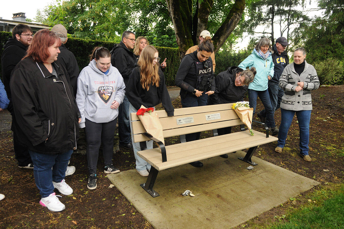 Family and friends of fallen RCMP officer Const. Rick O’Brien gather during the unveiling of a park bench dedicated to him at Fairfield Island Park in Chilliwack on Tuesday, March 28, 2024. (Jenna Hauck/ Chilliwack Progress)