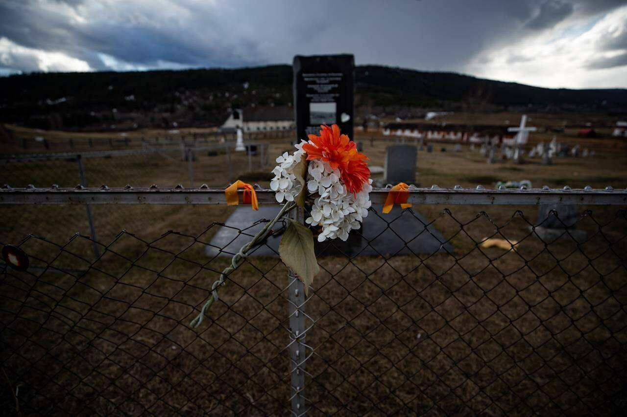 The B.C. government says the Williams Lake First Nation is planning to excavate the site of a former residential school to recover possible human remains and has signed an agreement with the province and RCMP to guide the process. Flowers are seen on a fence surrounding a cemetery on the former grounds of St. Joseph’s Mission Residential School, in Williams Lake, B.C., Wednesday, March 30, 2022. THE CANADIAN PRESS/Darryl Dyck