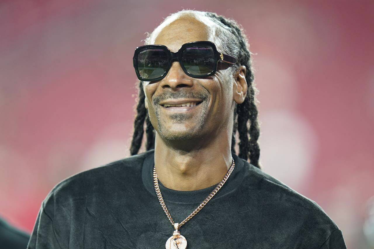 FILE - Entertainer Snoop Dogg walks on the field before an NFL football game between the Tampa Bay Buccaneers and the New Orleans Saints Sunday, Dec. 19, 2021, in Tampa, Fla. Snoop Dogg will serve as a primetime NBC correspondent for Paris Olympics. (AP Photo/Chris O’Meara, File)