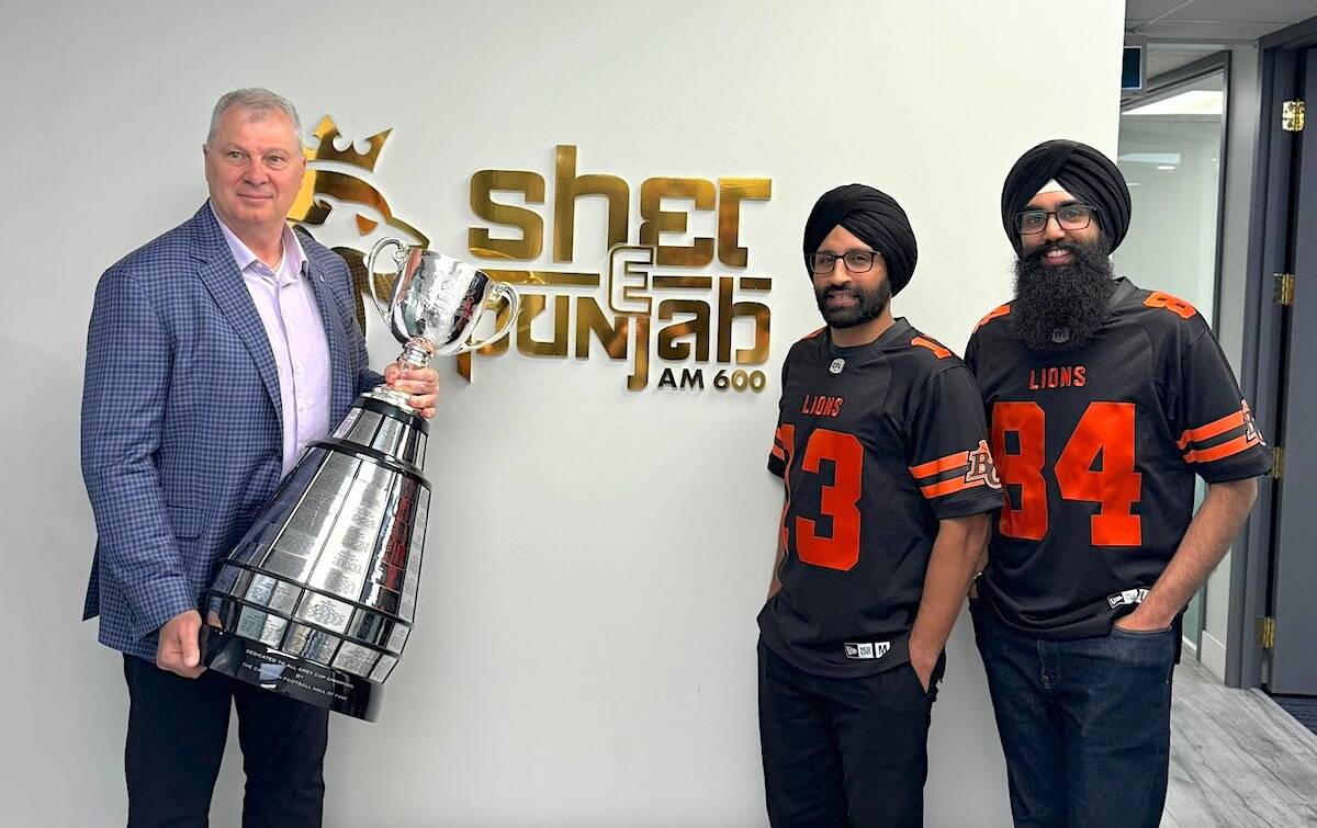 CFL commissioner Randy Ambrosie, holding the Grey Cup, at the Sher-E-Punjab radio headquarters with Lions Punjabi-language broadcasters Taqdeer Thindal, right, and Harpreet Pandher on Tuesday, June 4, 2024. (Contributed photo)
