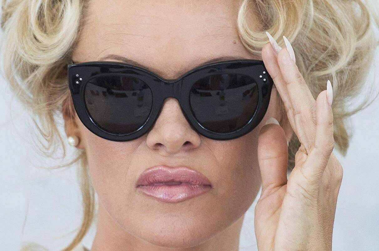 Actress Pamela Anderson adjusts her sunglasses during a press conference on the set of Sur Vie in Ile Bizzard, west of Montreal, Tuesday, August 9, 2016. THE CANADIAN PRESS/Graham Hughes