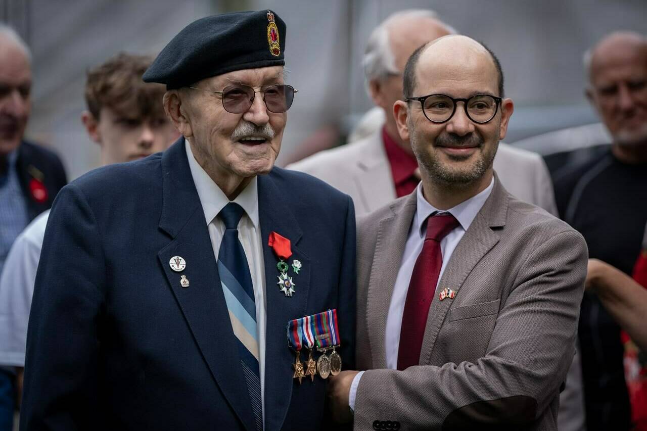 Canadian Veteran Joseph Vogelgesang, left, stands with the Consul General of France, Nicolas Baudouin, right, after he was presented with the insignia of “Knight of the Legion of Honour”, the French highest National Order, in Vancouver, on Thursday, June 6, 2024. THE CANADIAN PRESS/Ethan Cairns