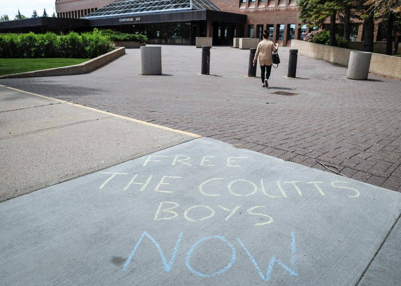 Words of support in chalk on the sidewalk as the trial for two men charged with conspiracy to commit murder during the border protest at Coutts, Alta., gets underway in Lethbridge, Alta., Thursday, June 6, 2024.THE CANADIAN PRESS/Jeff McIntosh