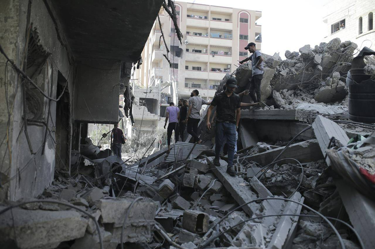 Palestinians look at the aftermath of the Israeli bombing in Nuseirat refugee camp, Gaza Strip, Saturday, June 8, 2024. (AP Photo/Jehad Alshrafi)