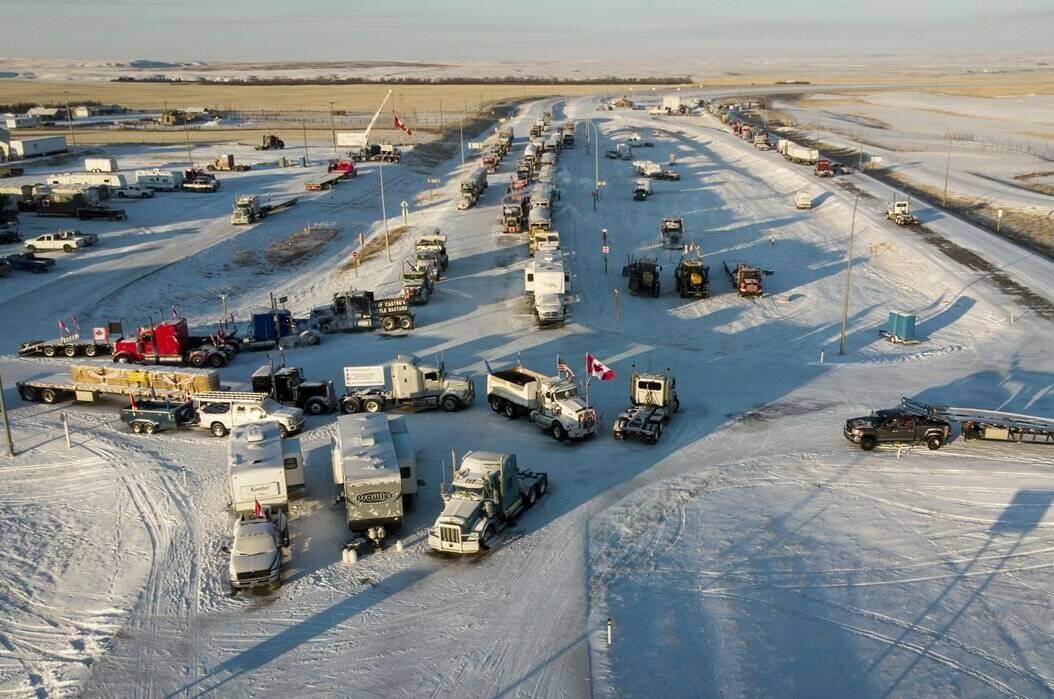 A truck convoy of anti-COVID-19 vaccine mandate demonstrators block the highway at the busy U.S. border crossing in Coutts, Alta., Wednesday, Feb. 2, 2022. A female undercover officer is set to continue her testimony Wednesday at a trial for two men charged with conspiracy to commit murder during the blockade. THE CANADIAN PRESS/Jeff McIntosh