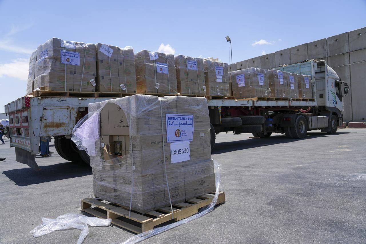 FILE - A bundle of humanitarian aid for the Gaza Strip with the logo of World Central Kitchen (WCK) is on a truck at the Kerem Shalom border crossing in southern Israel, on May 30, 2024. The amount of aid reaching the U.N. and other groups inside Gaza plunged last month, hundreds of crates packed with food, medicines and other supplies piled up in a parking lot in southeast Gaza. The cargo idling at the Kerem Shalom crossing crystallized a problem that arose after Israel invaded the southern city of Rafah in early May: Sending more aid to Gaza does no good if it cannot be distributed. (AP Photo/Tsafrir Abayov, File)