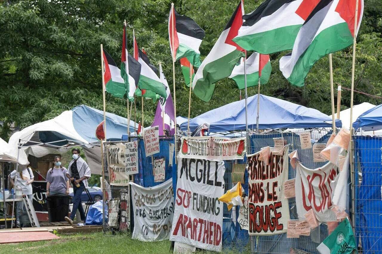 Supporters stand in front of the pro-Palestinian protest encampment on McGill University campus, in Montreal, Monday, June 17, 2024. THE CANADIAN PRESS/Ryan Remiorz