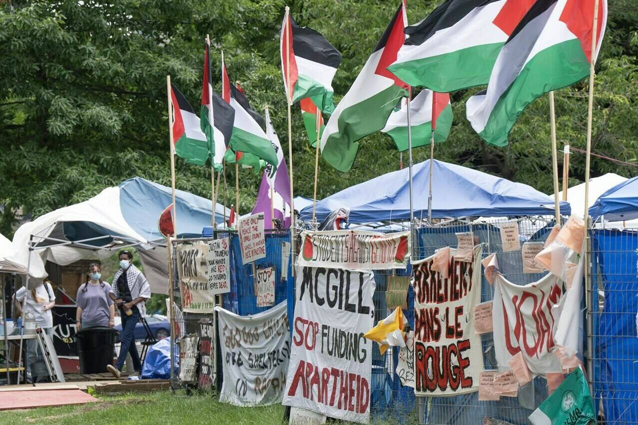 Supporters stand in front of the pro-Palestinian protest encampment on the downtown Montreal McGill University campus, Monday, June 17, 2024. McGill University says it is ending negotiations with pro-Palestinian activists at an encampment on its downtown campus. THE CANADIAN PRESS/Ryan Remiorz